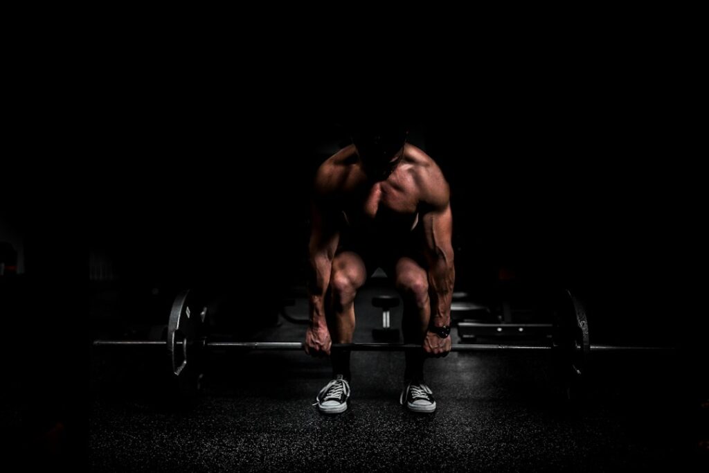 Adults performing controlled resistance exercises in a bright, well-ventilated gym with weights and water nearby.